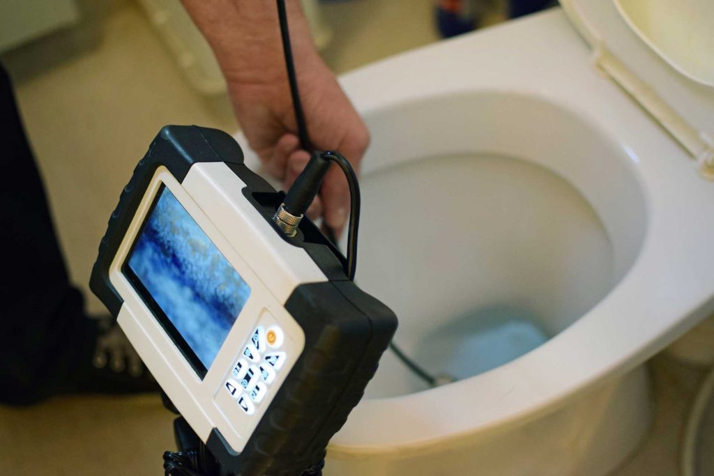 A video inspection probe running down through a toilet